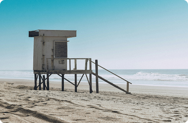 A quiet lifeguard tower standing on a sandy beach