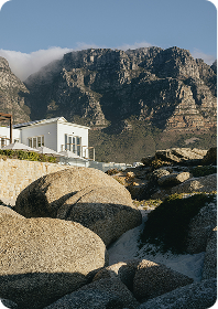 A mountain landscape viewed between large coastal rocks