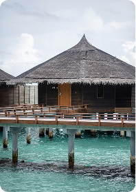 A traditional wooden island bungalow standing above turquoise water