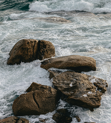 Ocean waves moving around coastal rocks