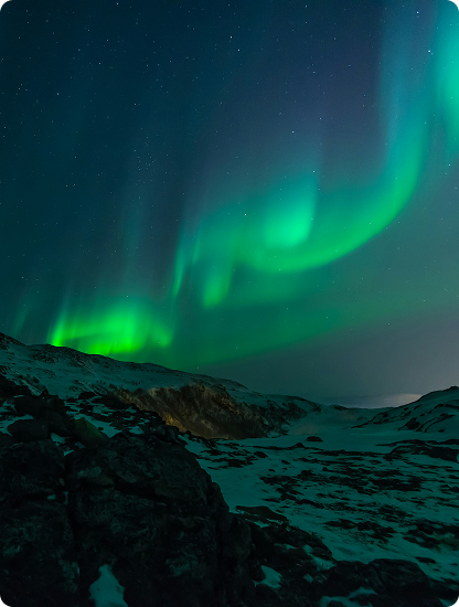 Green aurora over a snowy night landscape